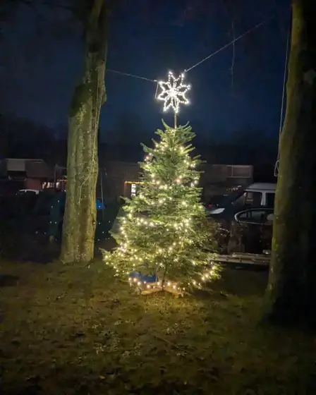 Verlichte buurtkerstboom met ster buiten