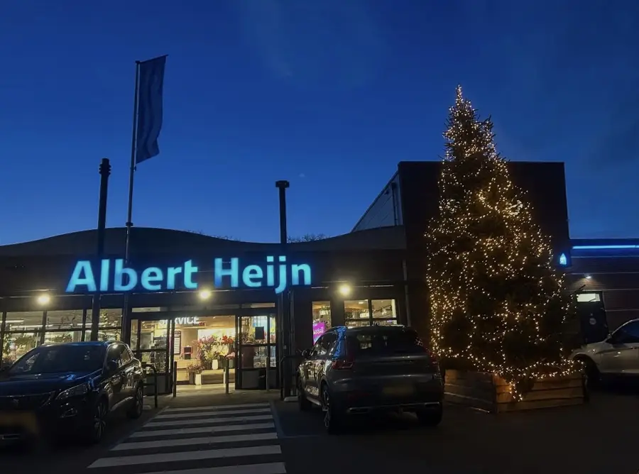 Grote verlichte XL-kerstboom bij de ingang van een Albert Heijn